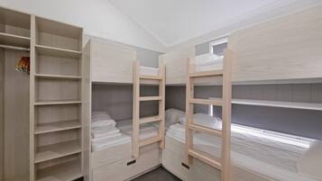 A room with bunk beds, a wardrobe, and a window.