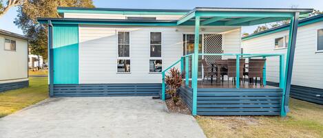 A single-story mobile home with a covered porch and a concrete driveway marked with the number 141.