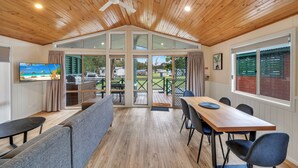 A dining area with a wooden ceiling, large windows, and a view of the outdoors. - Ingenia Holidays South West Rocks (South West Rocks)
