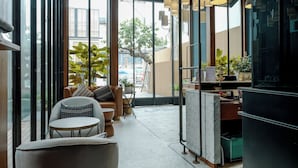 Un interior moderno con amplios ventanales, una zona de estar con una mesa y una encimera de cocina.