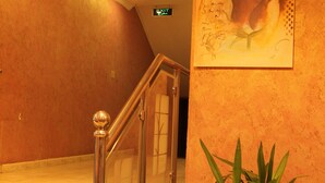 Eine Treppe mit Glastrennwand und einem Blumentopf.