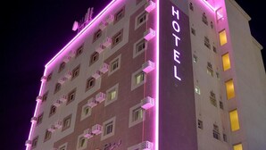 Ein Hotel mit mehreren Etagen, Balkonen und Neonreklame.