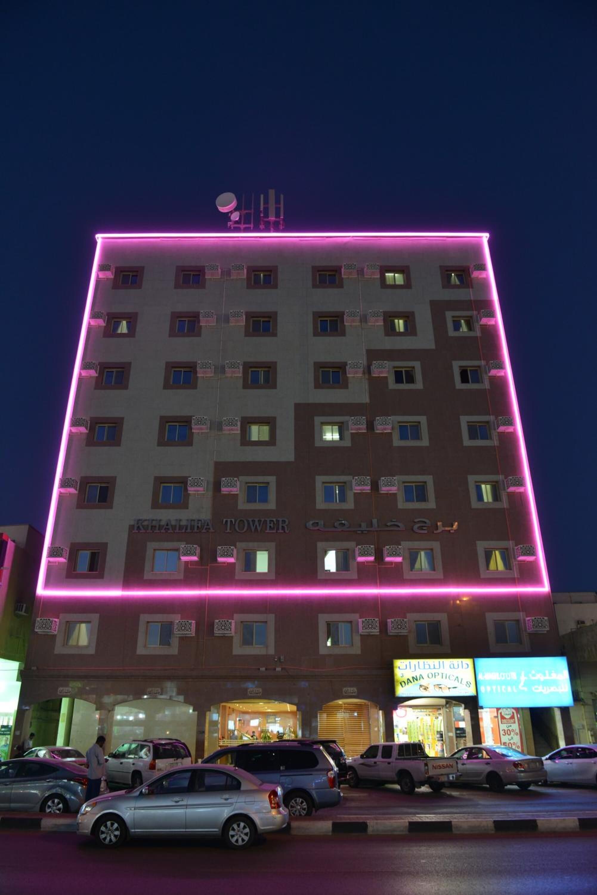 En bygning med en flad facade, flere vinduer og et skilt, der siger "Khalifa Tower".