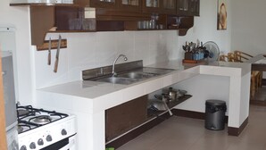 Una cocina con estufa, fregadero y armarios de madera.