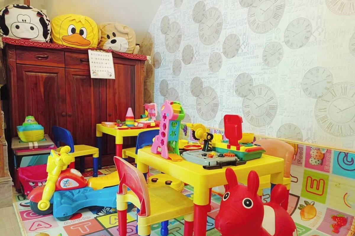 Ein Kinderzimmer mit bunten Spielsachen und einem Holzschrank.