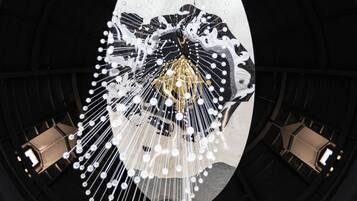 A large circular architectural structure with a central chandelier and multiple smaller lights.