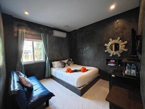 Un dormitorio con una cama, un banco, un espejo y un estante con artículos de tocador.