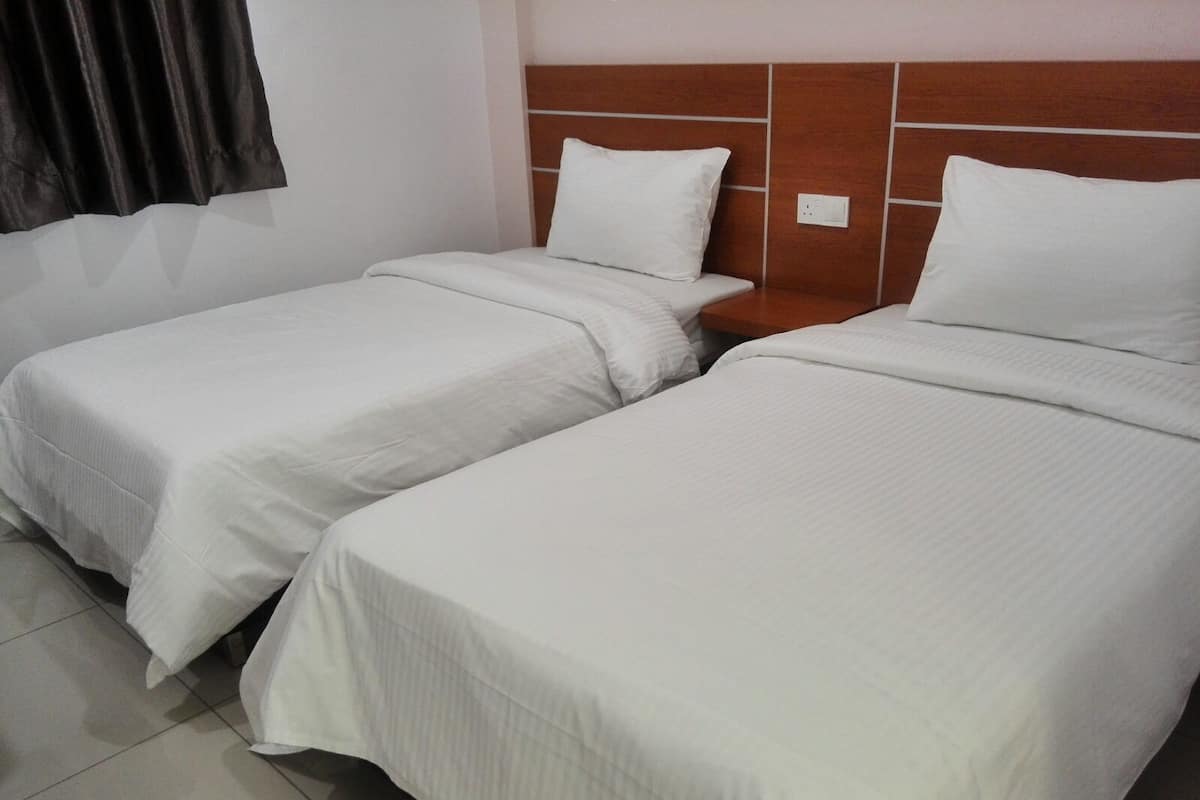 A hotel room with two single beds, a wooden headboard, and a tiled floor.