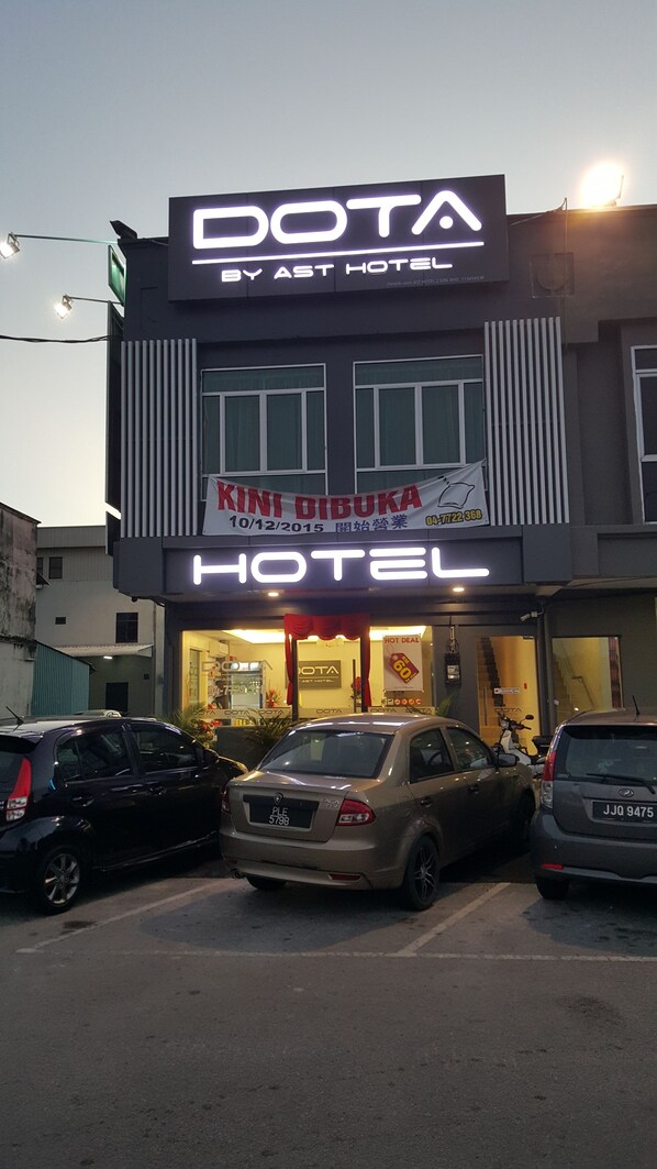 Un hotel con un cartel llamativo que dice 'DOTA', un cartel que dice 'HOTEL' y un banner que dice 'KINI DIBUKA'.
