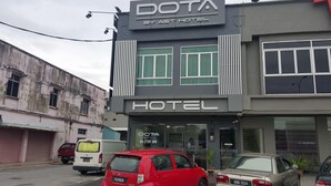 A modern hotel building with a prominent 'DOTA BY AST HOTEL' sign. - DOTA Hotel (Alor Setar)