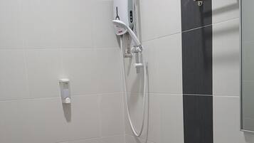 A modern bathroom with a white toilet, a shower unit, and a sink.