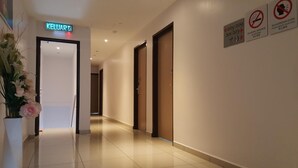 A hotel corridor with a 'KELUAR' sign, multiple doors, and signs prohibiting smoking and shouting. - DOTA Hotel (Alor Setar)