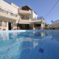 Una piscina al aire libre, sombrillas, sillones reclinables de piscina