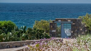 Una construcción de piedra con puerta de cristal que da al mar.