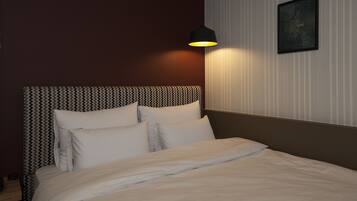 A neatly made bed with white linens, a headboard with a zigzag pattern, and a wall-mounted air conditioner.