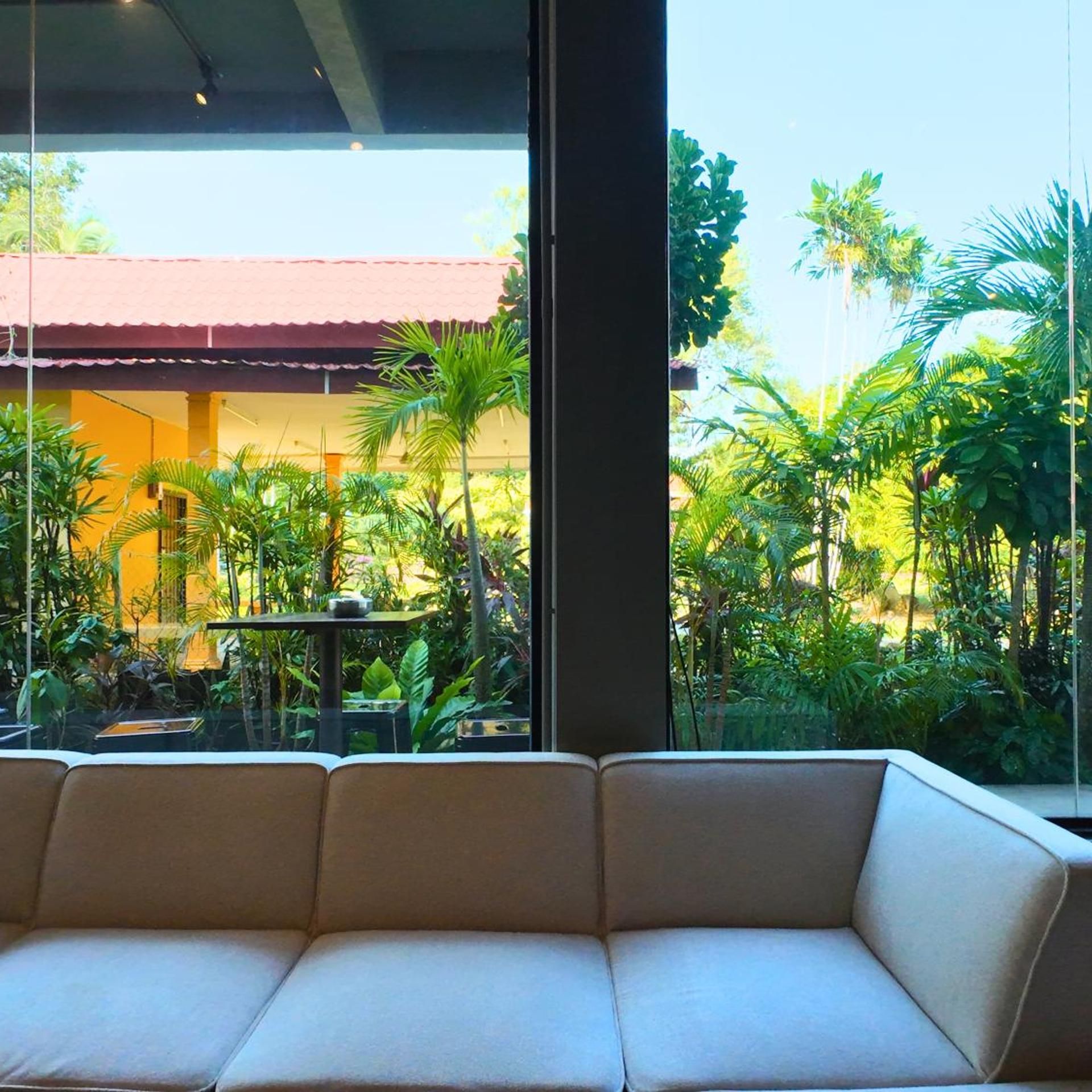 Una habitación con un ventanal grande que da a un jardín exuberante.