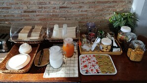 Un bufé de desayuno con sándwiches, jugos y diversas opciones de comida.