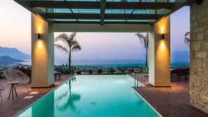 A pool area with a view of the city and mountains.