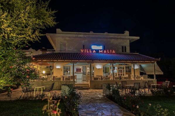 A villa named "Villa Malia" with outdoor seating and a stone pathway.