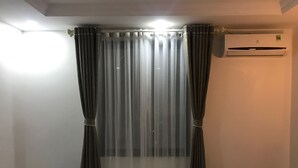 A room with a window covered by sheer curtains, an air conditioning unit on the wall, and a marble floor. - Sapa Memory Hotel (Sa Pa)