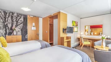 A hotel room with two beds, a desk, a chair, a TV, and a wardrobe.
