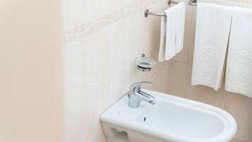 A bathroom with a white sink, a towel rack, and a mirror.