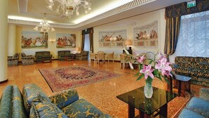 A spacious lobby with a chandelier, seating arrangements, and artwork on the walls. - Hotel Salus Terme (Abano Terme)