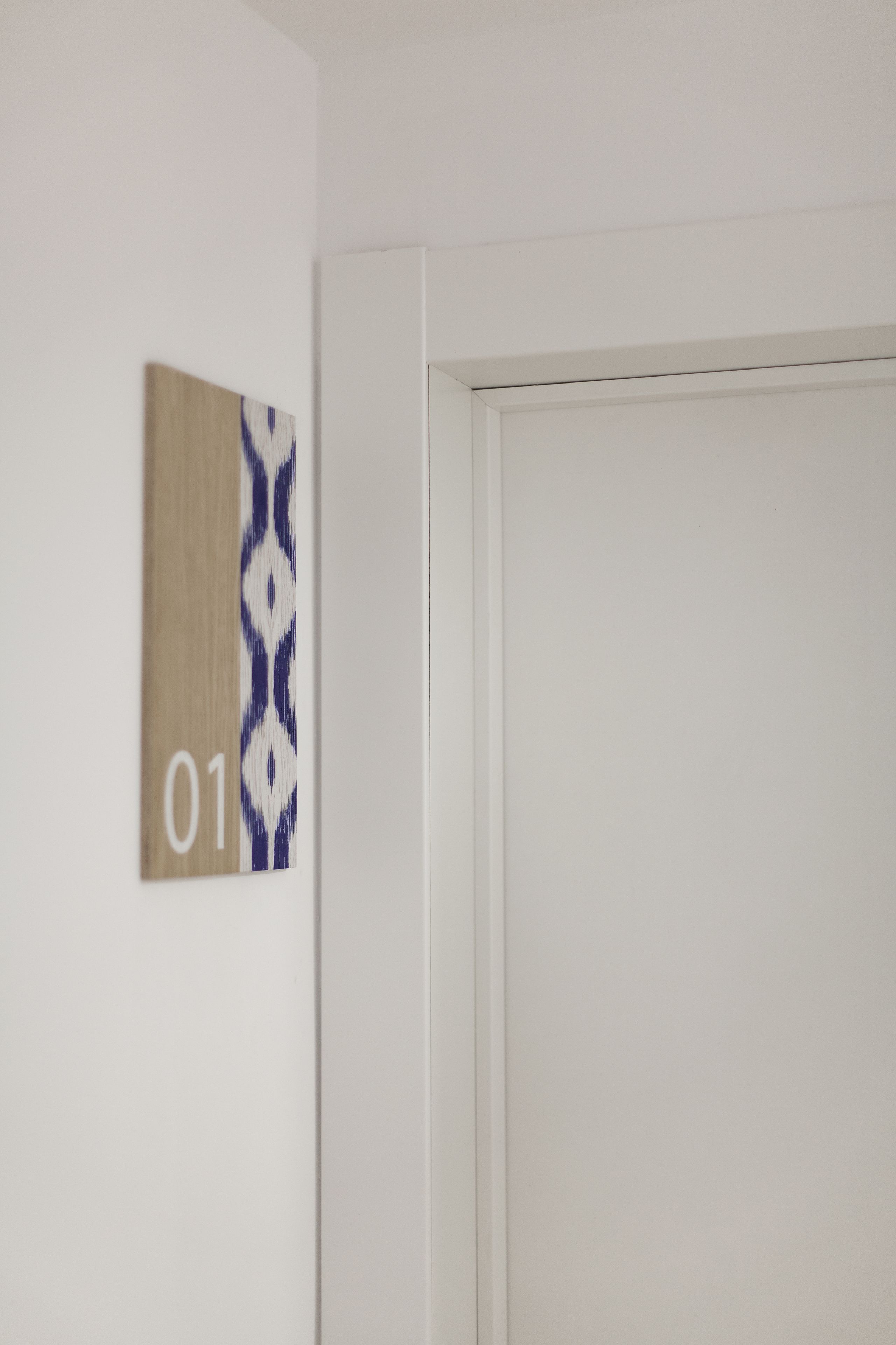 A room with a white door and a wall-mounted number sign '01'.