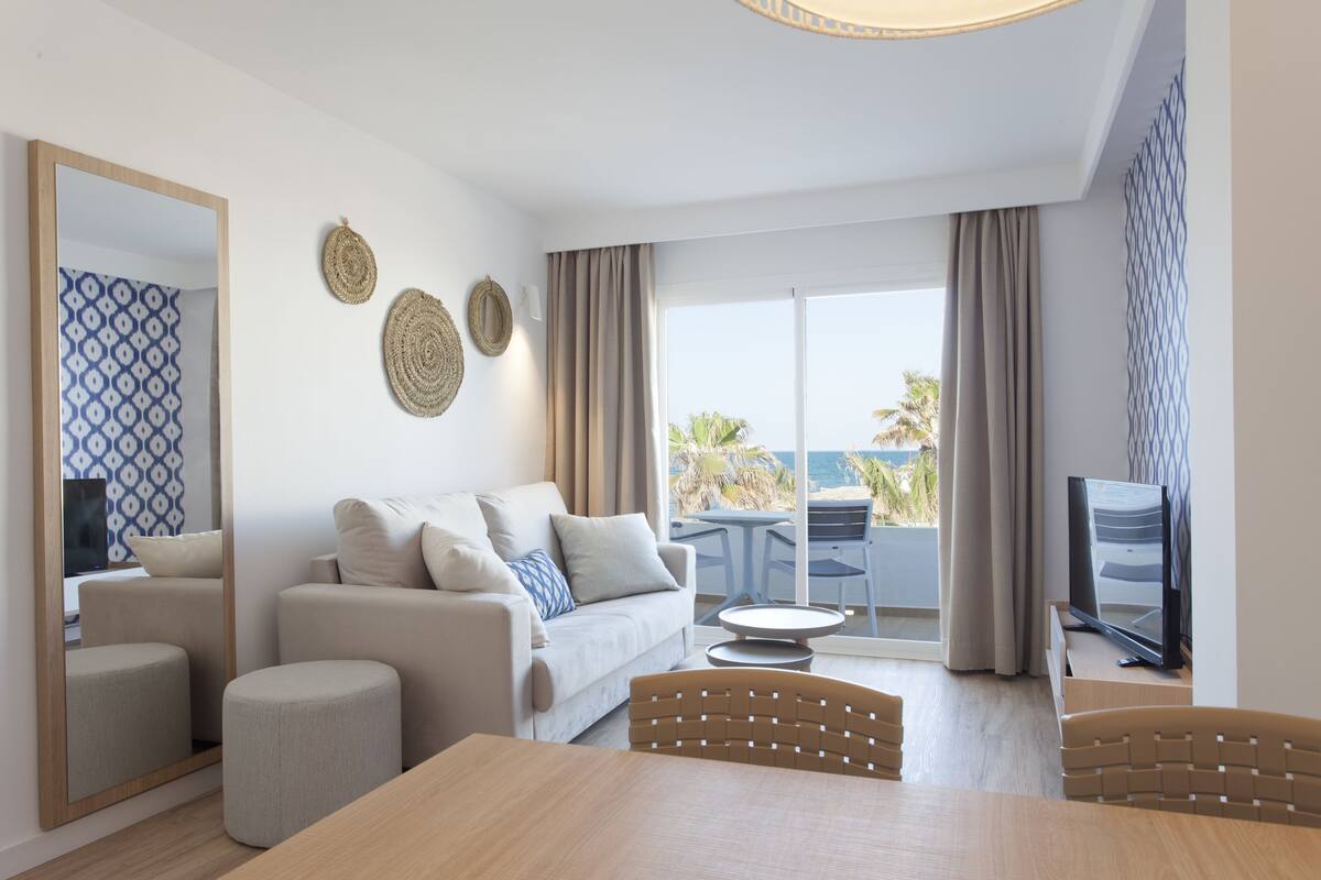 Een moderne woonkamer met een bank, poef en een eettafel.