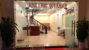 A hotel entrance with a staircase, a reception desk, and a red carpet. - Noi Bai Hotel (Hanoi)