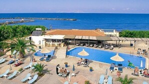 A resort with a large pool, sun loungers, and a view of the sea. - Kalia Beach (Hersonissos)