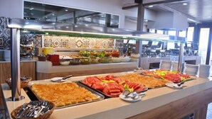 A buffet with various food items and utensils. - Kalia Beach (Hersonissos)