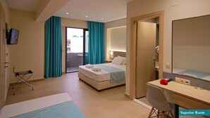 A hotel room with a bed, a desk, a chair, a mirror, and a television. - Kalia Beach (Hersonissos)