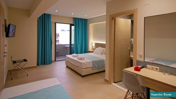 Une chambre d’hôtel équipée d’un lit, d’un bureau, d’une chaise, d’un miroir et d’une télévision.