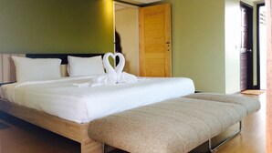 Una cama bien hecha con sábanas blancas y una decoración de toallas con forma de corazón.