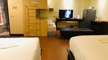 A hotel room with two beds, a TV, a desk, and a wardrobe.