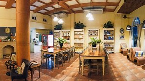 Un vestíbulo amplio con pared de ladrillo, mostrador de recepción y zona de estar con mesas y sillas.