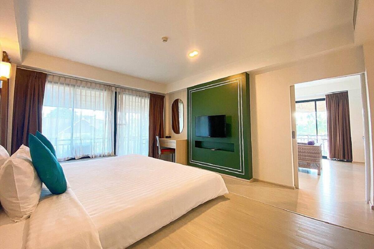 Une chambre d’hôtel avec un grand lit, un téléviseur à écran plat, un bureau et une vue sur l’extérieur.