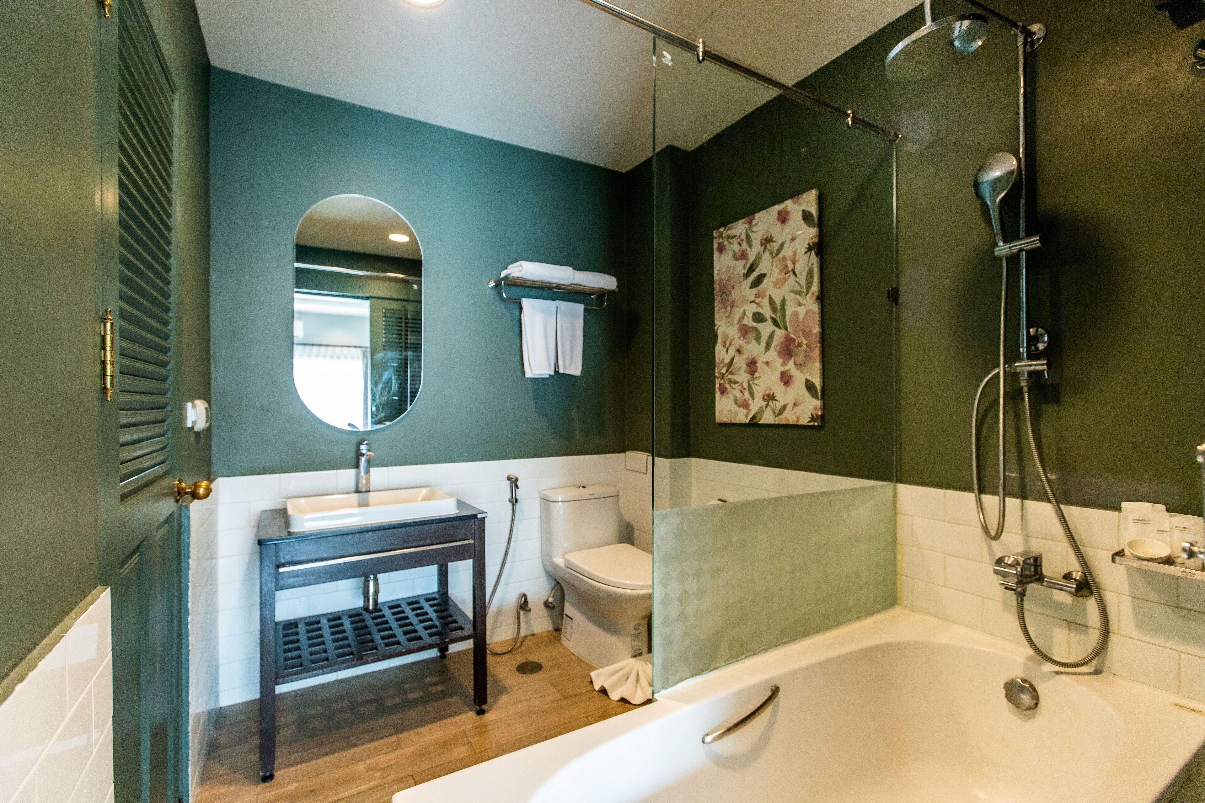 A modern bathroom with a glass-enclosed shower, a white sink, and a toilet.