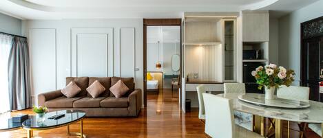 A modern living room with a sofa, coffee table, and dining table.