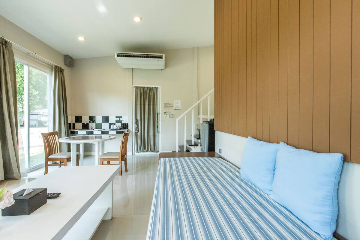 Une chambre d’hôtel moderne équipée d’un lit, d’un coin repas et d’une cuisine.