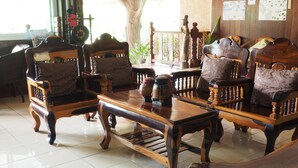 A traditional wooden furniture arrangement in a room with tiled flooring and a wooden railing. - Phutawan Kan Resort (Kanchanaburi)