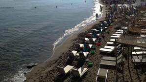 A beach with sun loungers, umbrellas, and a clear view of the sea. - Olympic Star Apartments (Hersonissos)