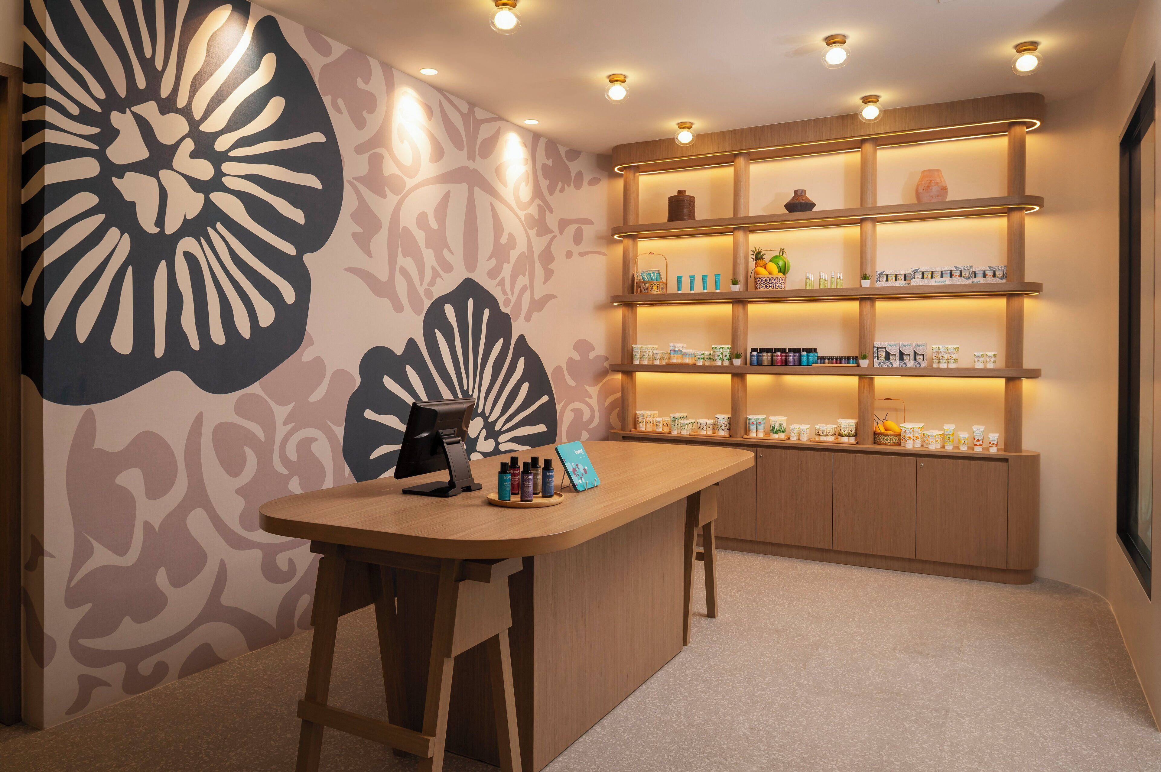 A bar area with a counter, shelves with bottles, and a decorative wall.