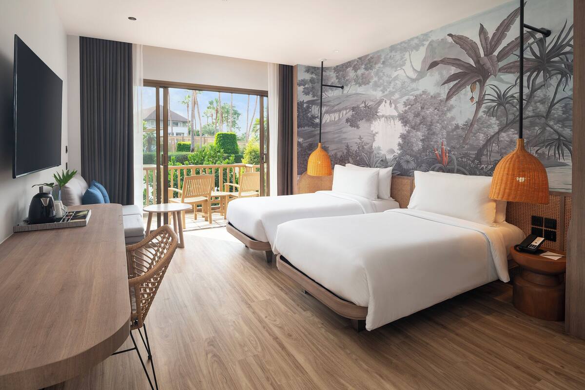 Habitación de hotel con dos camas, una mesa de comedor, televisión y balcón con vistas a palmeras.