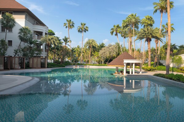 Alberca al aire libre, sombrillas en la alberca y camastros 