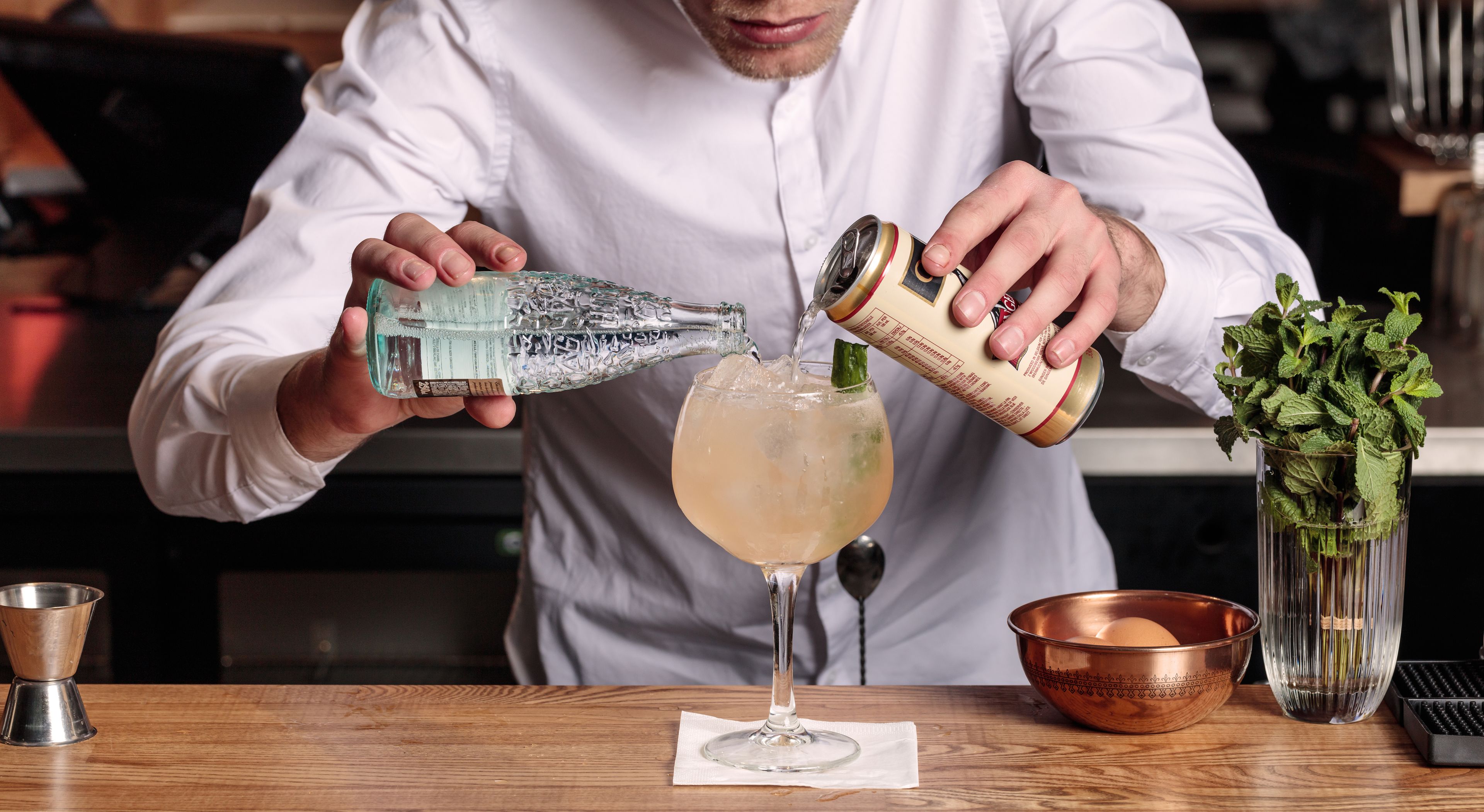 A person pouring a drink into a glass.