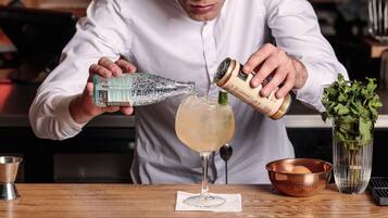 A person pouring a drink into a glass.