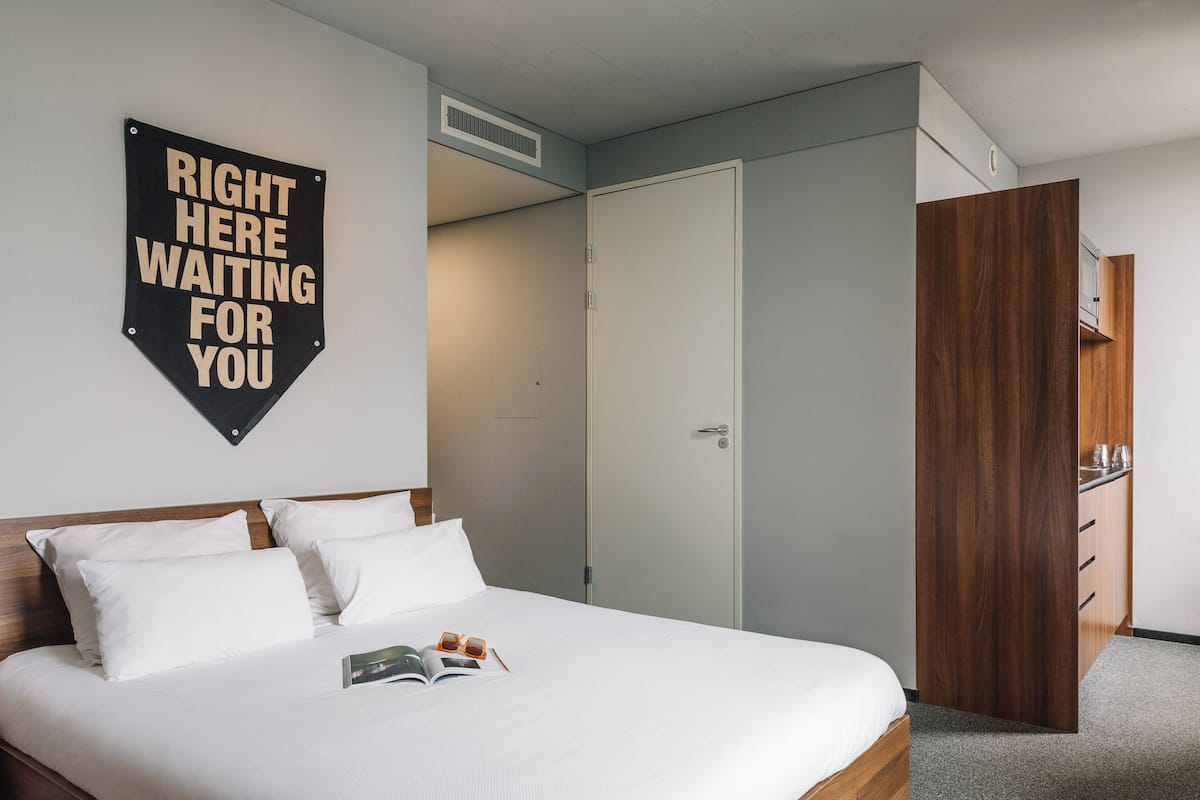 Ett hotellrum med en säng, en garderob och en skylt på väggen.