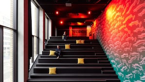Una escalera con cojines amarillos que lleva a una habitación con un mural de peces rojos y amarillos.